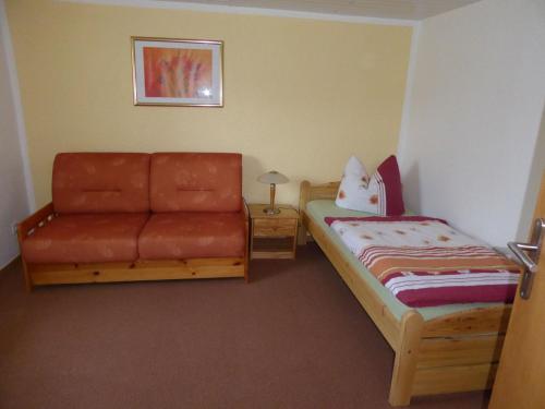 Un dormitorio pequeño con una cama y un sofá. en Bungalow in Zweedorf mit Liegewiese, en Zweedorf