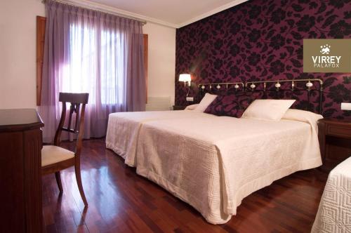 a hotel room with a large bed and a window at Hotel II Virrey in El Burgo de Osma