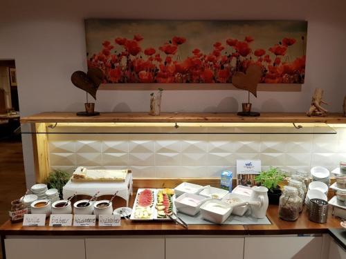 a counter with a table with food and flowers on it at Lieblingsplatz Tirolerhof in Zell am Ziller