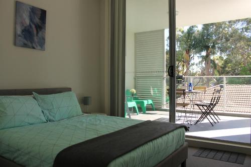 a bedroom with a bed and a balcony with a patio at Enjoyable Holiday Home For Group Six in Waitara