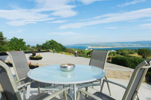 a table and chairs with a view of the ocean at On the Rocks B&B in Greencastle