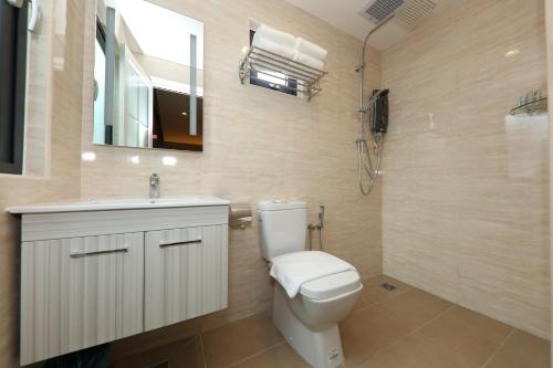 a bathroom with a toilet, sink, and mirror at Double M Hotel @ Kl Sentral in Kuala Lumpur