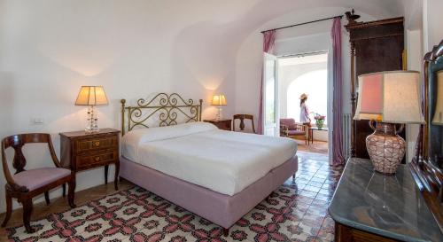 a bedroom with a bed and a table and a chair at Villa Lindo in Maiori