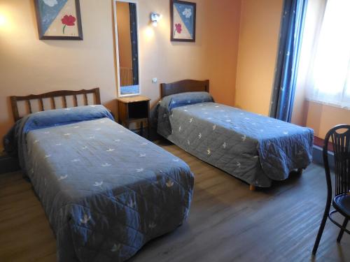 a bedroom with two beds and a mirror at Hotel de la gare in Cosne-Cours-sur-Loire
