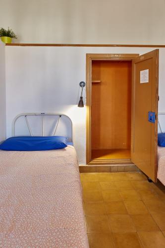 a bedroom with a bed with a door and a closet at Albergue Seminario Menor in Santiago de Compostela