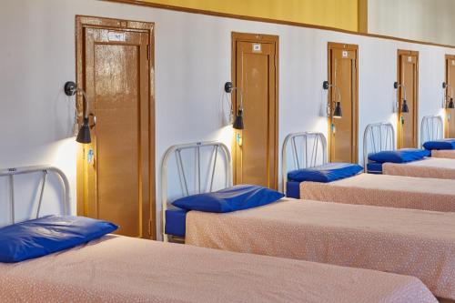 a row of beds in a room with blue pillows at Albergue Seminario Menor in Santiago de Compostela