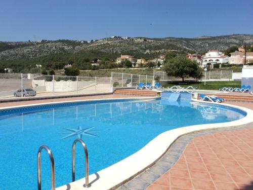 a swimming pool with blue water in a resort at Residencial Marcomar Casa Azahar in Alcossebre