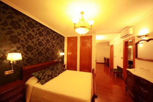 a bedroom with a large bed and a room with at Hotel II Virrey in El Burgo de Osma