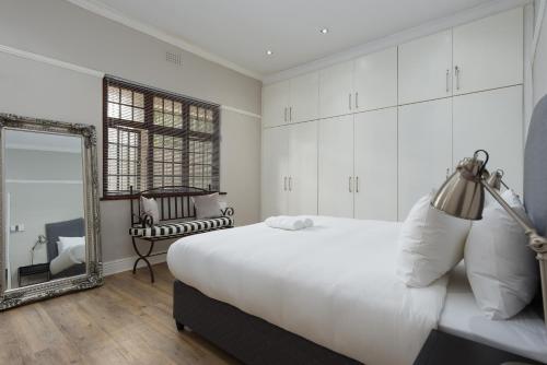 a bedroom with a large bed and a mirror at Vesperdene Mews 2 in Cape Town