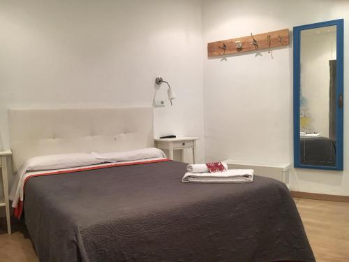 a bedroom with a bed with two towels on it at Hostal Portugal in Barcelona