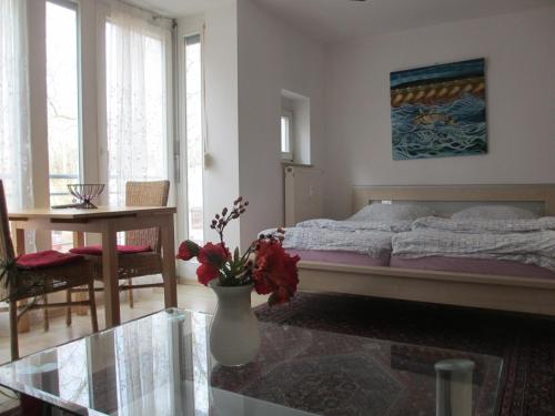 a bedroom with a bed and a table and a vase with flowers at Im Zentrum Katharinenstr. in Freiburg im Breisgau