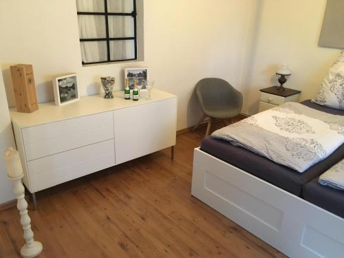 a bedroom with a white dresser and a bed at Landhaus zum adeligen Klosterforst in Pohnsdorf