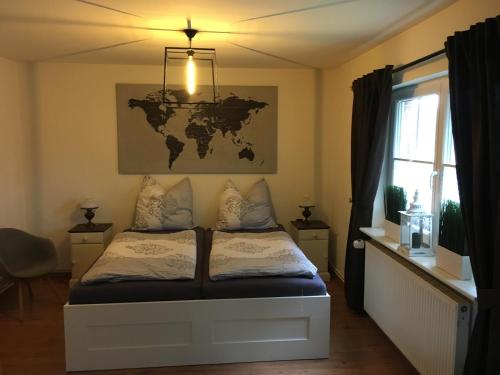 a bedroom with a bed with a map on the wall at Landhaus zum adeligen Klosterforst in Pohnsdorf