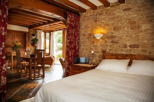 1 dormitorio con cama y mesa con ordenador portátil en Heath Farm Holiday Cottages, en Swerford