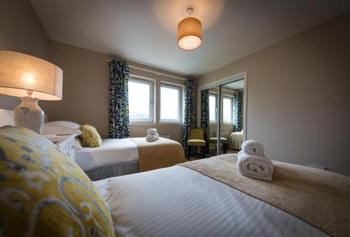a hotel room with two beds and a window at Taigh Mhuirne in Portree