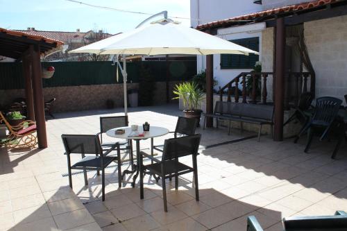 a table and chairs under an umbrella on a patio at Hostel Casa Lucas in Charneca