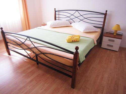 - une chambre avec un grand lit et du parquet dans l'établissement Apartments Susnja, à Vodice