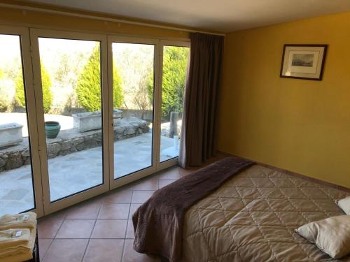 een slaapkamer met een bed en glazen schuifdeuren bij Quinta do Atoleiro in Lamego