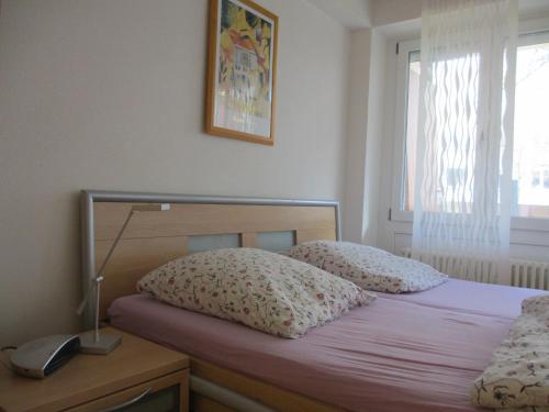 1 dormitorio con 1 cama con 2 almohadas y lámpara en Im Zentrum Am Hebelhof 1Zi., en Freiburg im Breisgau