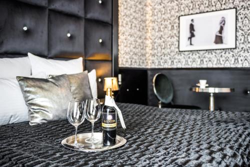 a hotel room with two wine glasses on a bed at Hotel Luxor in Lublin