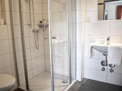 y baño con ducha y lavamanos. en Apparthotel Ampertal, en Kranzberg