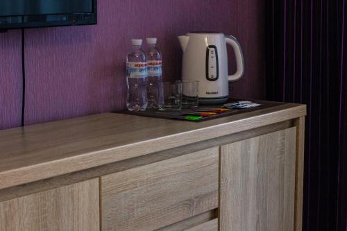 a counter with a coffee maker and water bottles on it at Solo Apartment Dragomanova in Kyiv