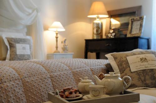 Una cama con una bandeja con tazas y galletas. en La Garçonniere-Suite in Salerno centro, en Salerno