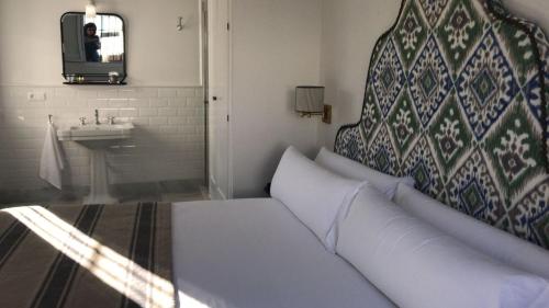 - un canapé blanc dans une salle de bains pourvue d'un lavabo dans l'établissement nüa santiago15, à Séville