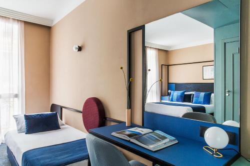Un pat sau paturi într-o cameră la Hôtel les Cigales