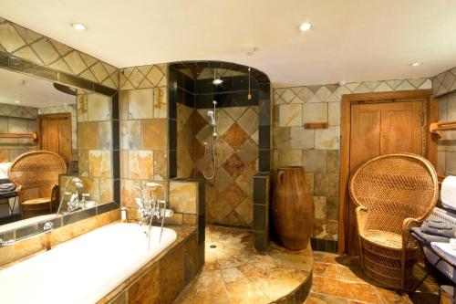 Un baño grande con bañera y ducha. en Heath Farm Holiday Cottages, en Swerford