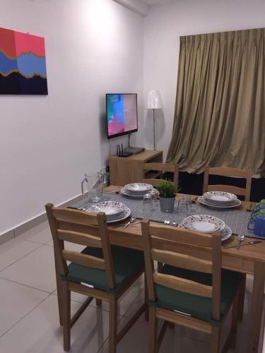 a dining room table with chairs and plates on it at Meridin Medini Muslim Condo in Nusajaya