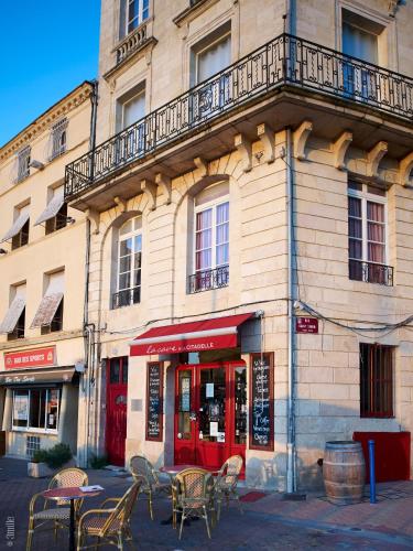 a building with tables and chairs in front of it at Bordeaux Village Blaye in Blaye