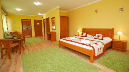 a bedroom with a bed and a desk and a table at Hotel Járja in Hajdúszoboszló