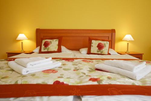 a bedroom with two beds with towels on them at Hotel Járja in Hajdúszoboszló