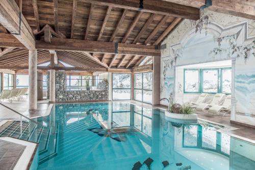 een zwembad in een huis met een plafond bij Hotel Elisabeth, 4 Sterne Superior in Kirchberg in Tirol