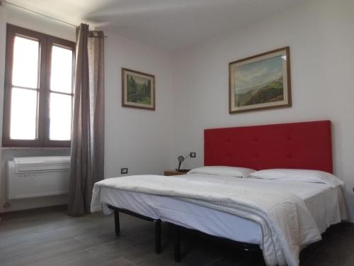 a bedroom with a large bed with a red headboard at Hotel Sole Holiday in Arco