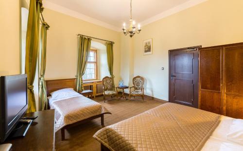 a hotel room with two beds and a tv at Zamek Czocha in Leśna