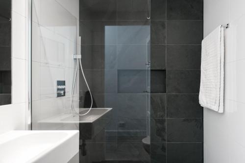 a bathroom with a glass shower with a sink at GH Amsterdam in Amsterdam