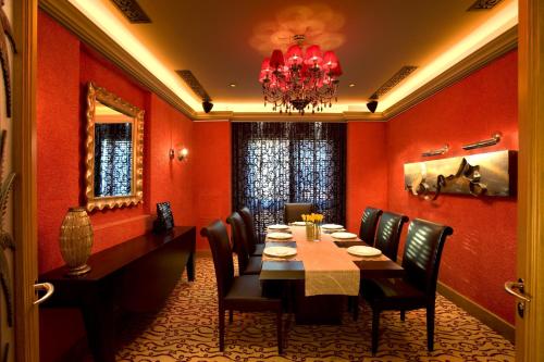 a dining room with a table and chairs and a chandelier at Shangri-La Qaryat Al Beri, Abu Dhabi in Abu Dhabi