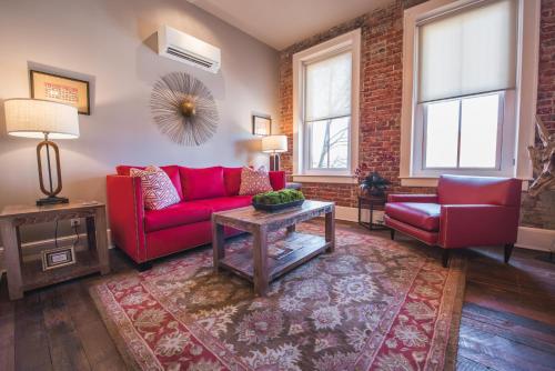 a living room with red furniture and a brick wall at The Windsor - Asheville in Asheville