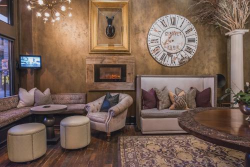 a living room with chairs and a clock on the wall at The Windsor - Asheville in Asheville