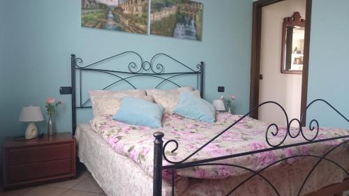 een slaapkamer met een bed met een metalen frame bij IEO - HUMANITAS - MILANO CENTRO a 15 minuti in Locate di Triulzi
