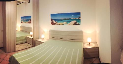 a bedroom with a bed and two night stands with lights at Appartamento Lungomare in Marciana Marina