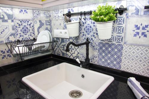 Baño con lavabo y azulejos azules y blancos en Casa Gigi Tarifa, en Tarifa