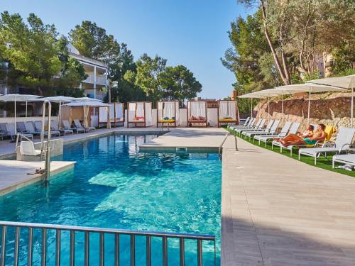 a pool with chairs and umbrellas at a hotel at BQ Bulevar Peguera- Adults Only in Paguera