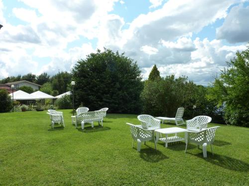 a group of white chairs and tables on a lawn at La Rocca in Narni