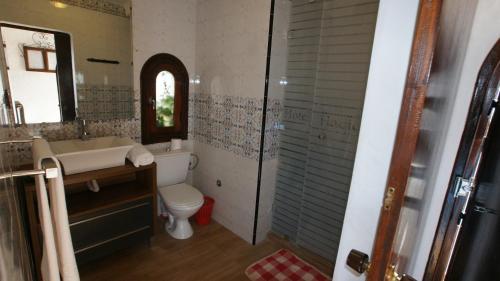 een badkamer met een wastafel, een toilet en een spiegel bij Hotel Hacienda in Martil