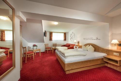 um quarto com uma cama grande e uma sala de estar em Das Wismeyer em Obertauern