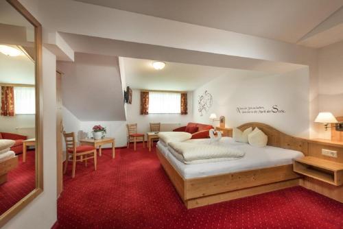 sypialnia z dużym łóżkiem i salonem w obiekcie Das Wismeyer - Skihotel an der Plattenkarbahn w mieście Obertauern