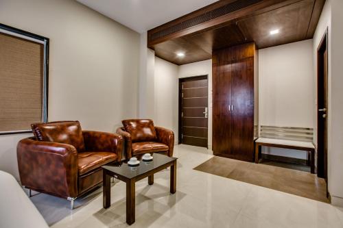 a living room with two leather chairs and a table at Hotel Ma Grand in Pudukkottai